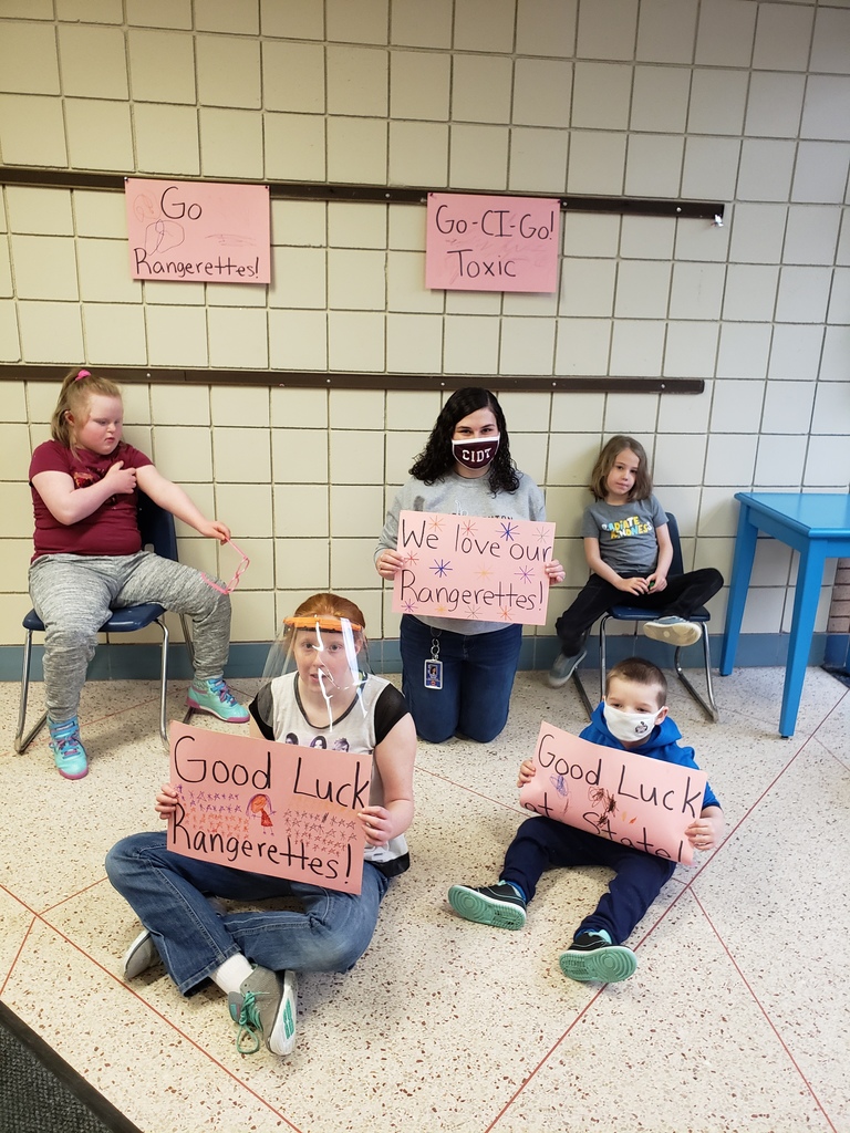 students and staff holding signs