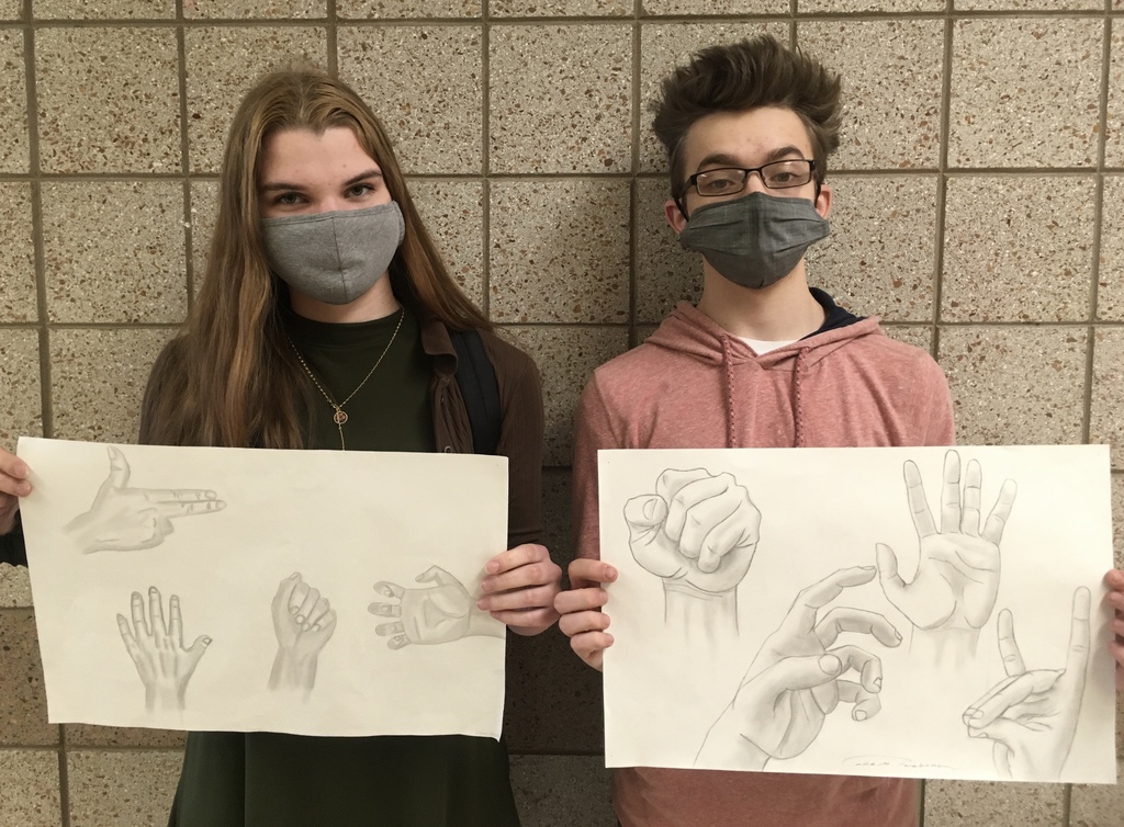 female and male student holding drawings of hands