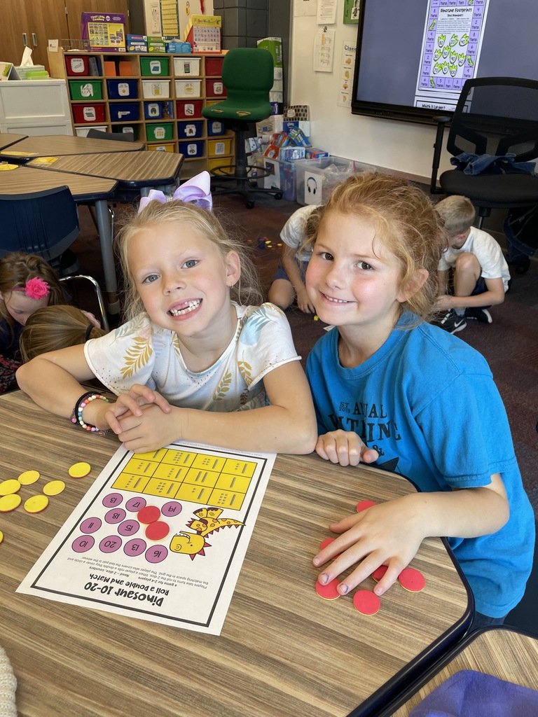 2 girls at a desk with yellow and red chips