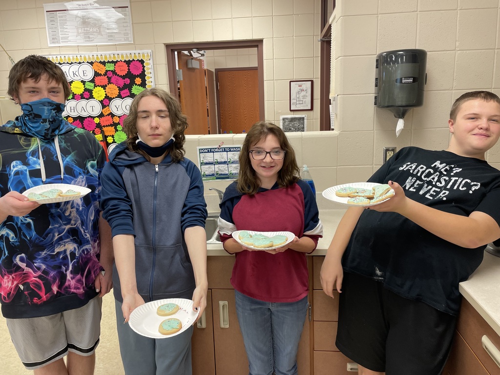 four students holding their plates of cookies