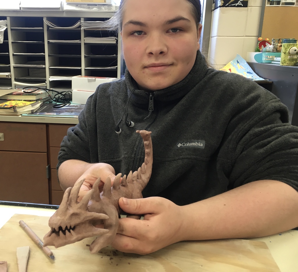 male holding dinosaur clay art