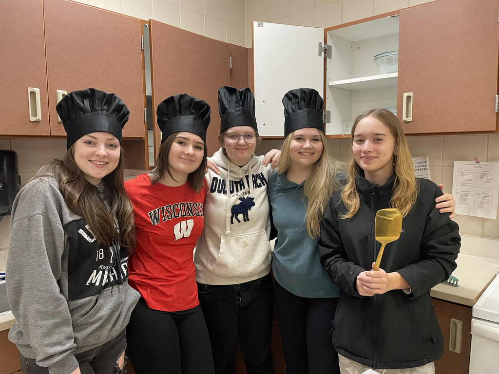 5 students one holding a golden spatula