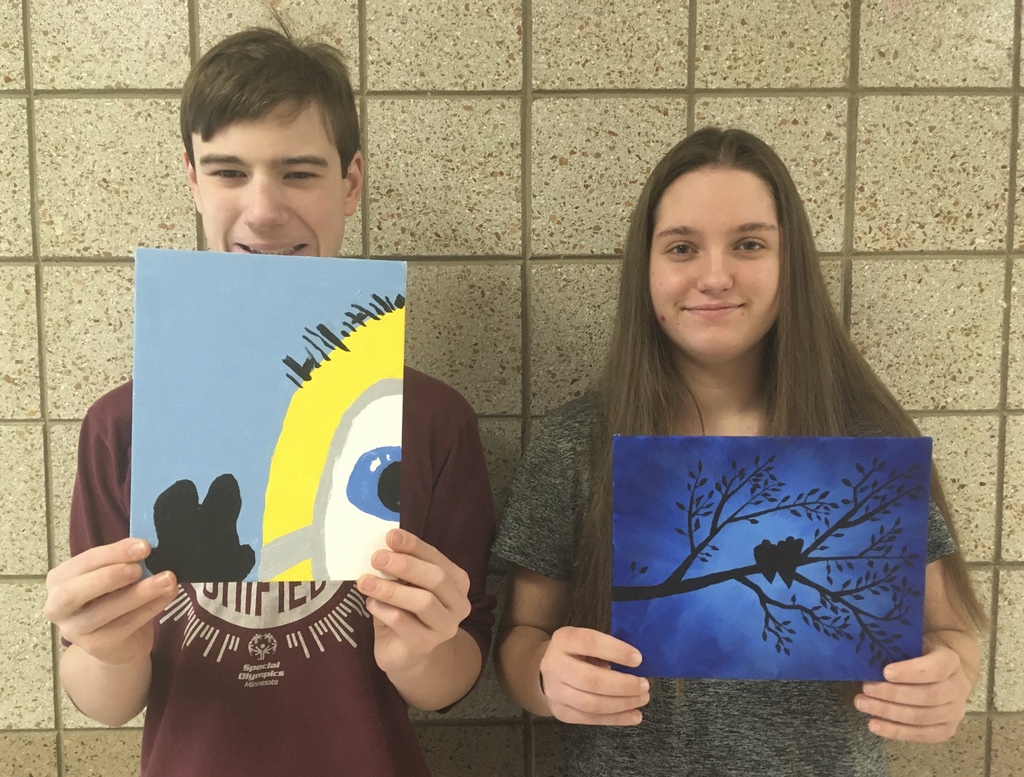 students holding silhouette paintings