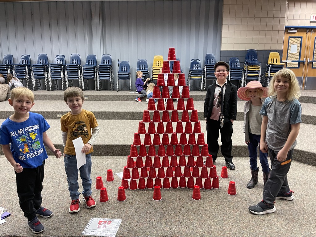 5 students standing next to a tower