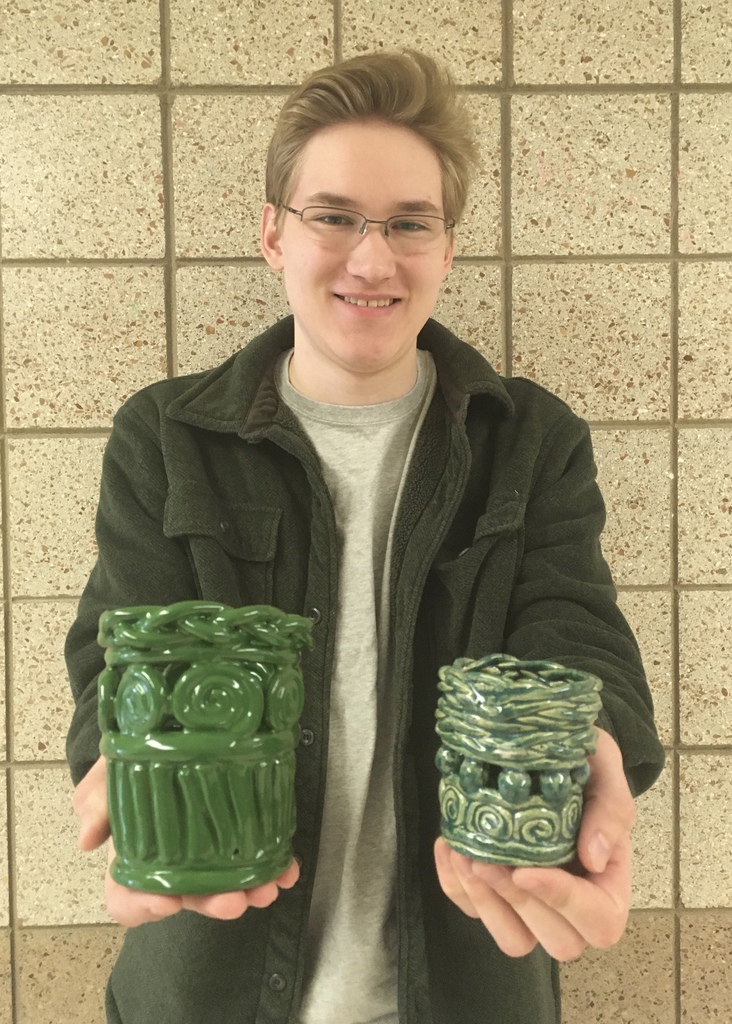student holding two clay pots