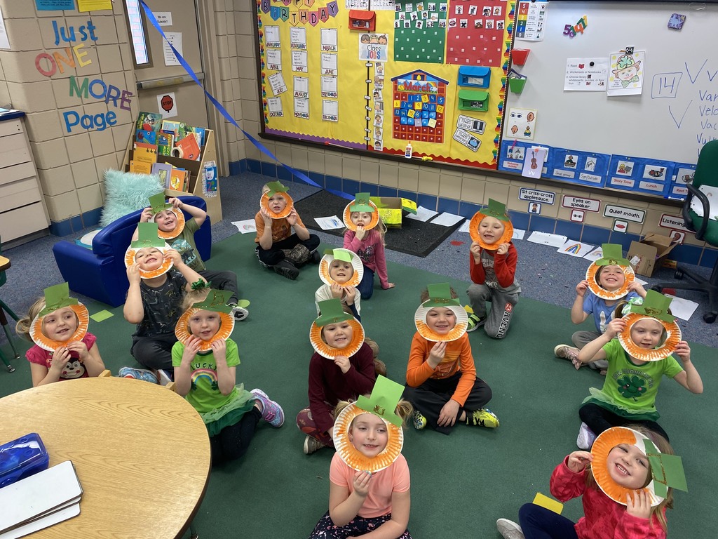 students sitting on the floor with leprechaun masks