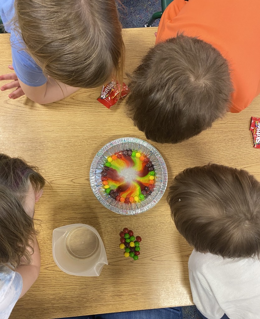 a bowl of skittles in water