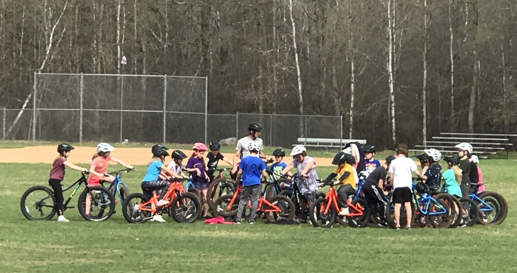 students on bikes around the teacher