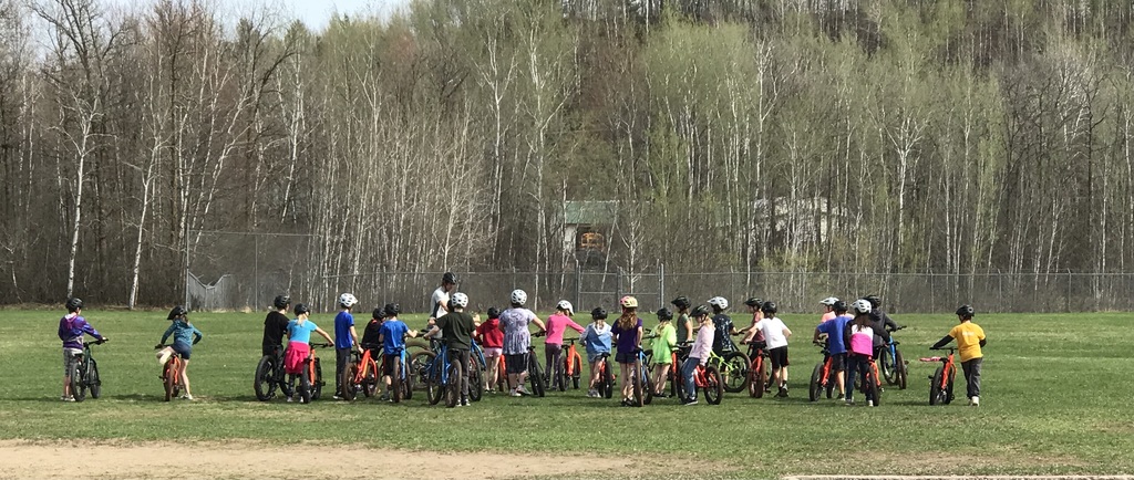 students standing next to bikes and their teacher