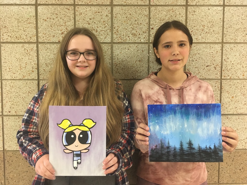 students holding paintings