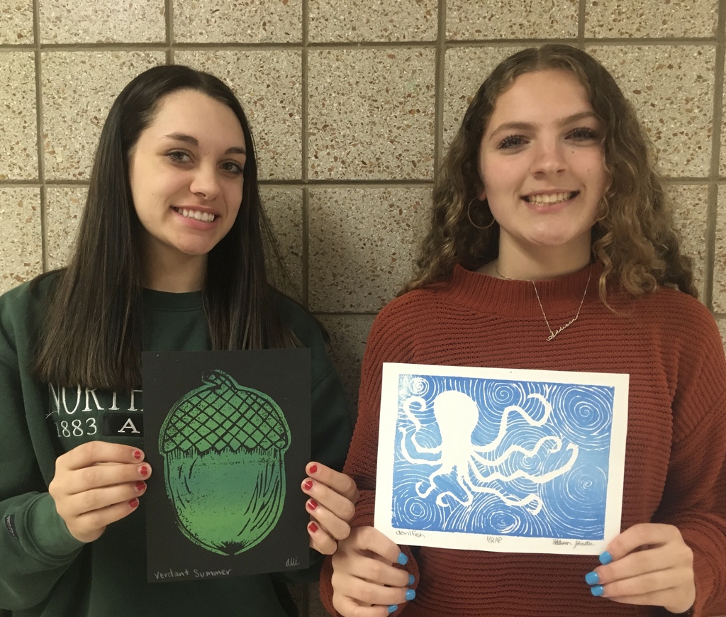 two students holding prints