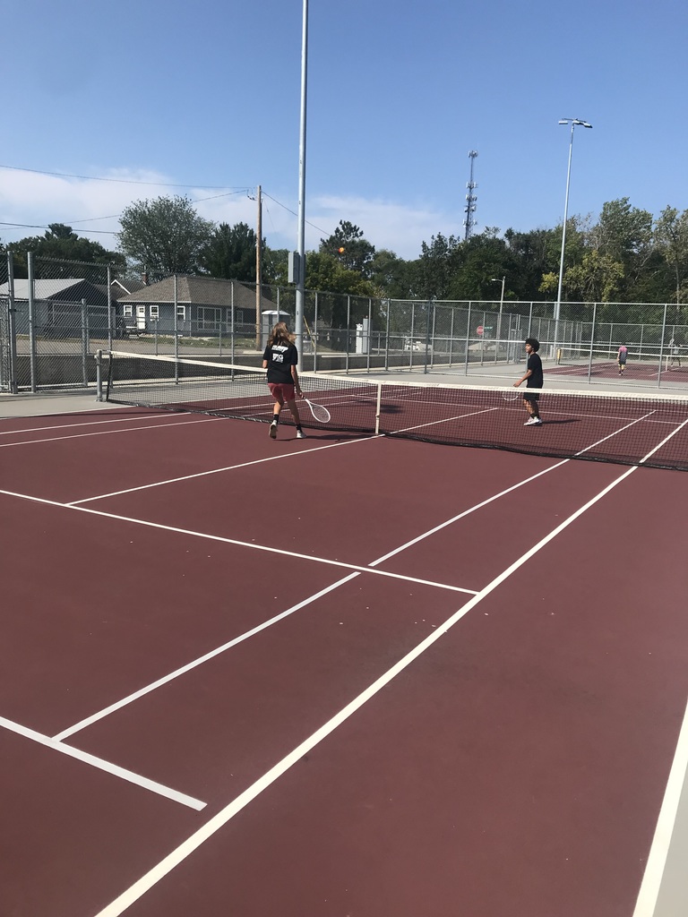 two students playing tennis