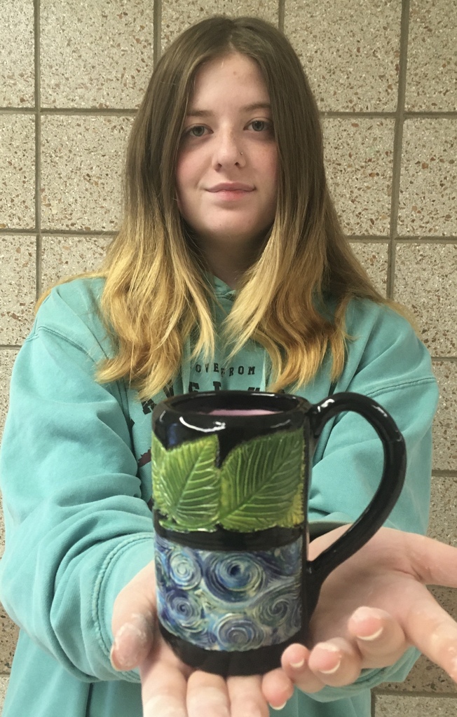 a student holding a stamp mug