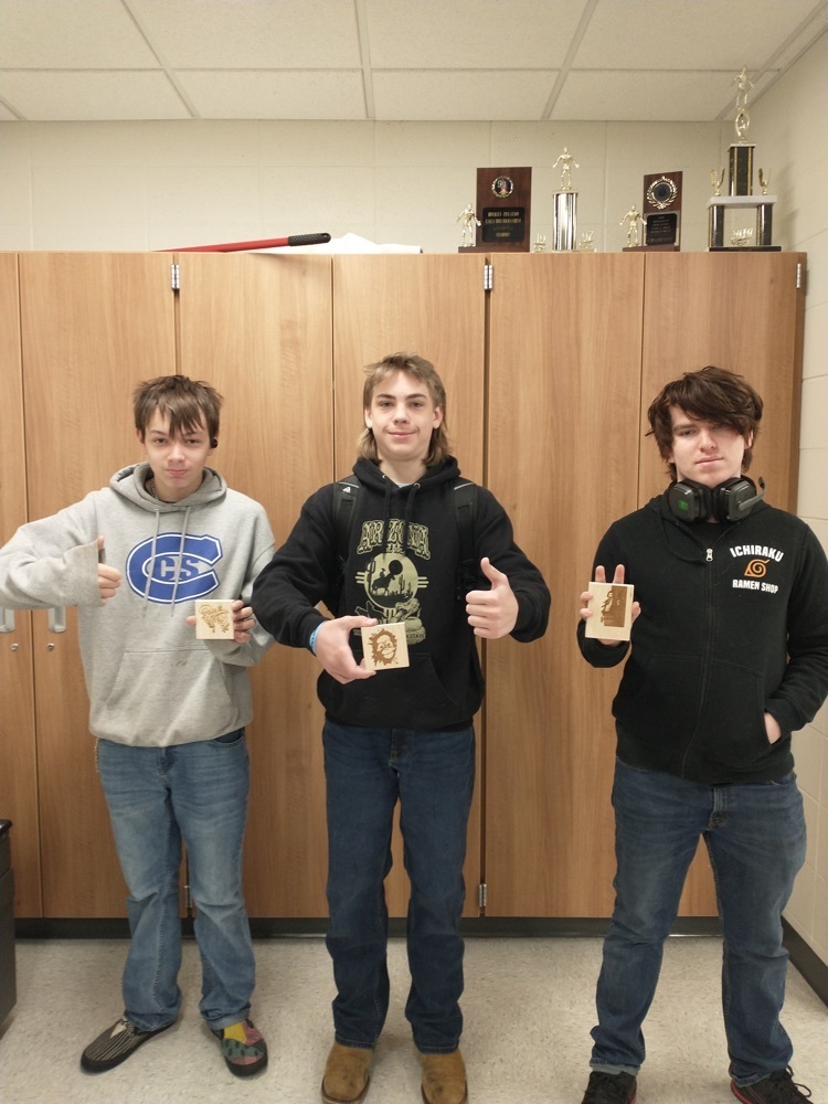 three students with laser engraved wood