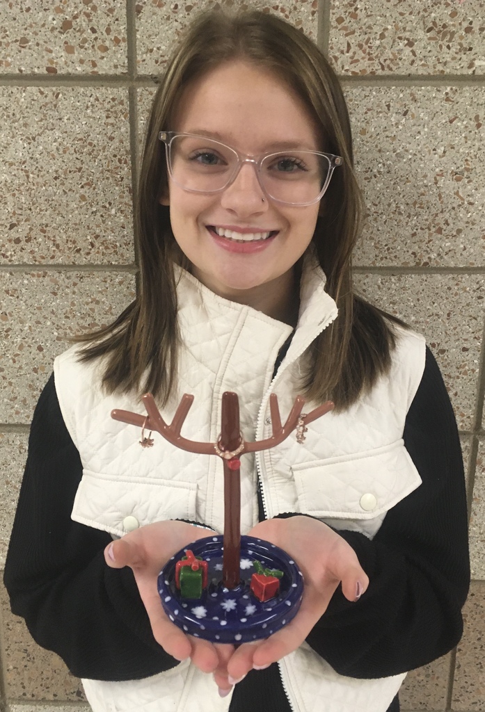 student holding a reindeer ring holder