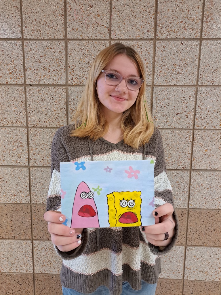 female student holding a painting of spongebob