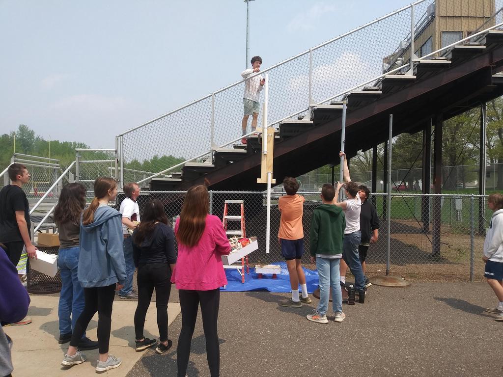 one student on the bleachers with students watching