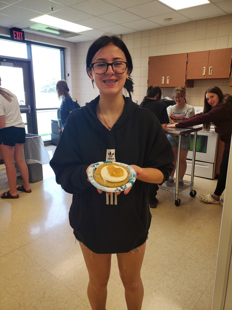 student holding a peach cookie