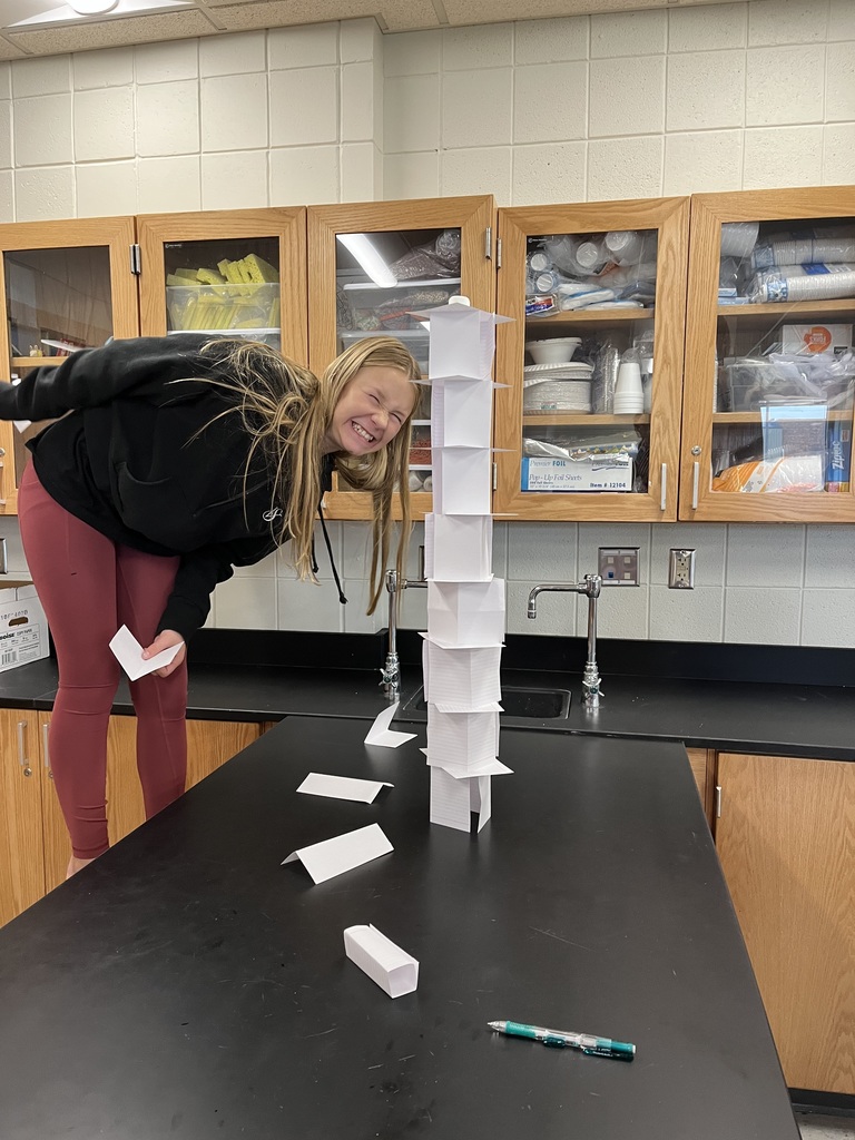 female student standing next to a tower of notecards