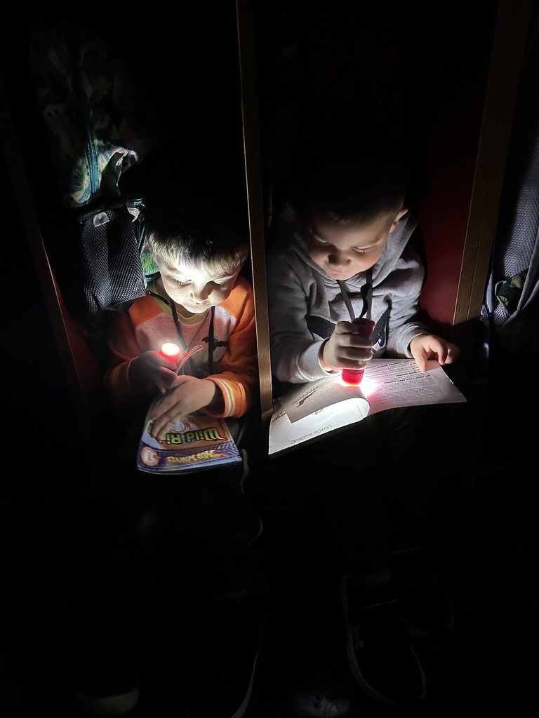 two students with flashlights reading
