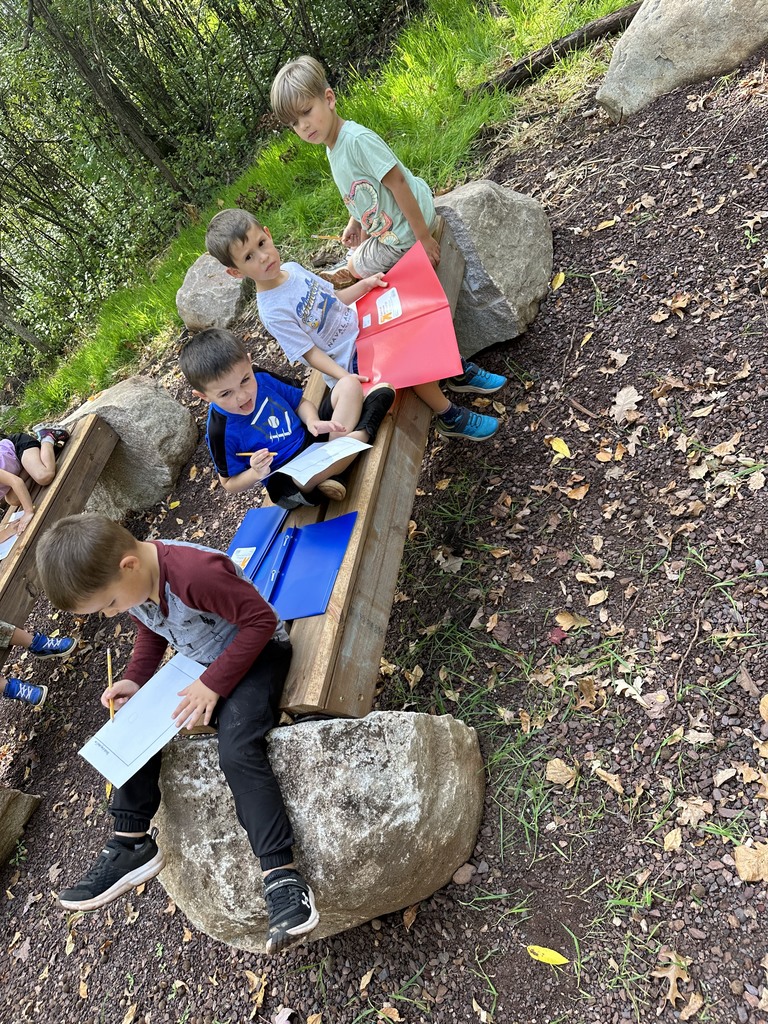 students sitting on a bench with folders