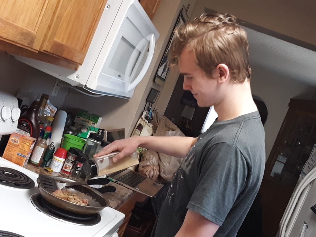 a male cooking over the stove