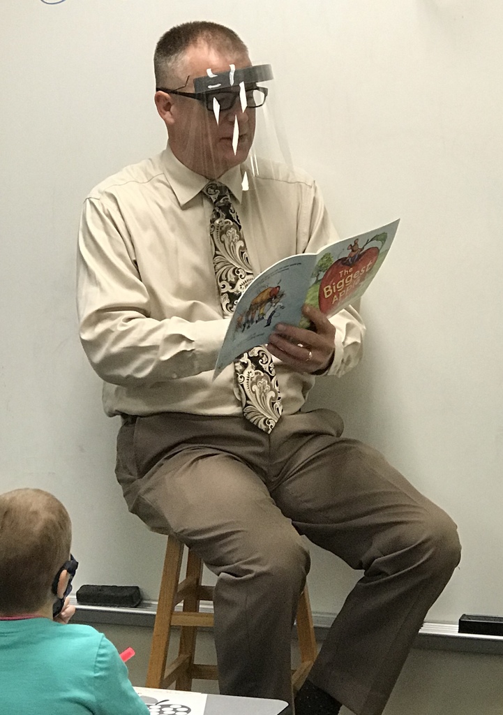 male superintendent reading a book